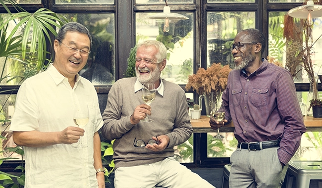 3 middle age men smiling, drinking wine