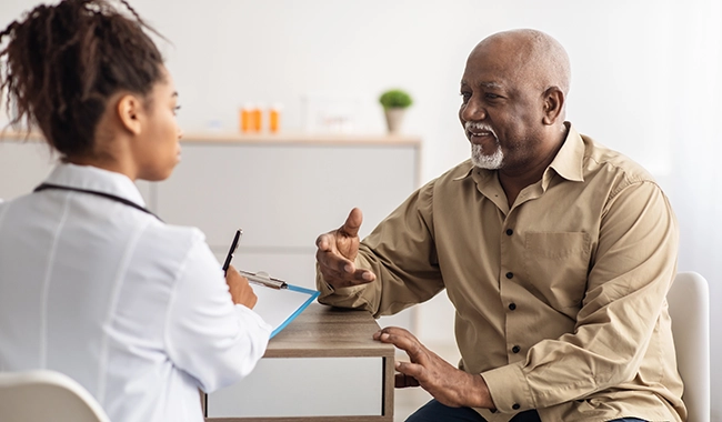 middle age male patient talking with female doctor