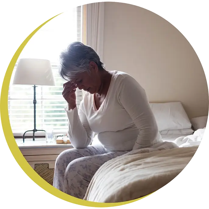 woman sitting up in bed with head in hand